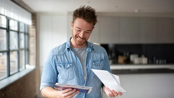 Creating Direct Mail That Works Webinar - Man reading direct mail in his kitchen 