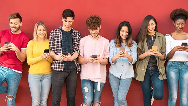 Marketing to Generation Z - Group on their phones in front of a red background