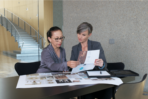 Two women in an office looking over print and digital marketing
